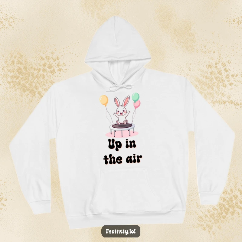 Funny Bunny Trampoline Hoodie depicts a cheerful bunny enthusiastically bouncing on a balloon-filled trampoline, radiating happiness.