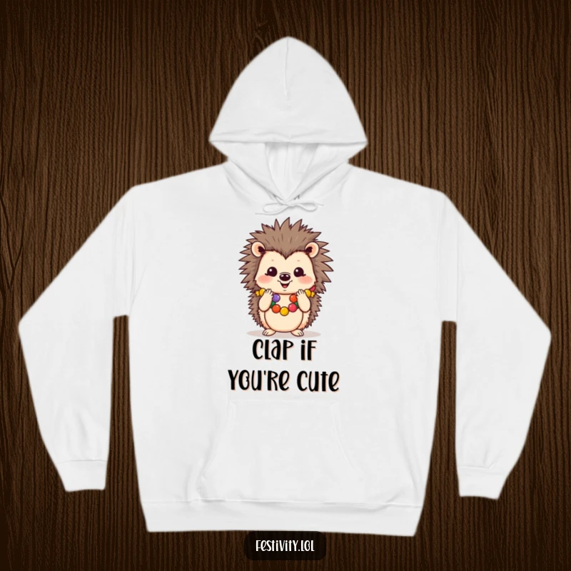 Funny hoodie showing a cheerful hedgehog in a festive garland, clapping its paws, perfect for cozy celebrations.